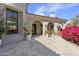 Charming covered patio features elegant arches, travertine floors, and lush landscaping at 19494 N 98Th Pl, Scottsdale, AZ 85255