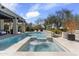 An in-ground pool and spa is surrounded by desert landscaping and a travertine deck at 19494 N 98Th Pl, Scottsdale, AZ 85255