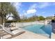 Backyard pool with stone waterfall feature and surrounding desert landscaping. Two lounge chairs offer poolside relaxation at 19494 N 98Th Pl, Scottsdale, AZ 85255