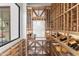 Custom wine room with wooden shelving for ample storage, a window with a bright exterior view, and white walls at 19494 N 98Th Pl, Scottsdale, AZ 85255