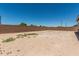View of a fenced-in backyard featuring desert landscaping and retaining wall at 20624 S 216Th Pl, Queen Creek, AZ 85142