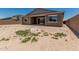 View of the home's backyard, highlighting the stucco exterior, windows, and patio at 20624 S 216Th Pl, Queen Creek, AZ 85142