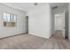 Carpeted bedroom with an open doorway and large windows at 20624 S 216Th Pl, Queen Creek, AZ 85142