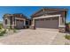 Exterior view of the house highlighting the two-car garage, brick driveway, and landscaping at 20624 S 216Th Pl, Queen Creek, AZ 85142