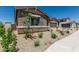Charming home exterior featuring stone accents, gray shutters, and desert landscaping for a low-maintenance yard at 20624 S 216Th Pl, Queen Creek, AZ 85142