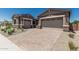 Beautiful home exterior featuring a two-car garage, stone accents, and a paved driveway for added curb appeal at 20624 S 216Th Pl, Queen Creek, AZ 85142