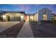 Charming home exterior with a red front door, desert landscaping, and a two-car garage at 21240 W Sycamore Dr, Buckeye, AZ 85396