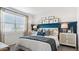 Comfortable bedroom featuring a decorative headboard, ambient lighting, and light-filtering window at 23997 W Cocopah St, Buckeye, AZ 85326