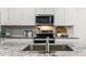 Modern kitchen with stainless steel appliances, granite counters and a stainless steel sink at 23997 W Cocopah St, Buckeye, AZ 85326