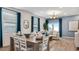 Elegant living room with hardwood floors, modern chandelier, and large windows with blue curtains at 23997 W Cocopah St, Buckeye, AZ 85326