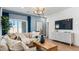 Stylish living room with blue accent wall, modern lighting, and comfortable seating at 23997 W Cocopah St, Buckeye, AZ 85326