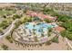 Expansive aerial view showcasing the community pool and clubhouse with meticulously landscaped grounds and palm trees at 26648 W Quail Ave, Buckeye, AZ 85396
