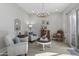 Elegant living room with tile floors, soft armchairs, a decorative chandelier, and a glass door for natural light at 26648 W Quail Ave, Buckeye, AZ 85396