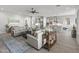 Spacious living room with wood floors, gray couches, with an open view of the kitchen and island at 26648 W Quail Ave, Buckeye, AZ 85396