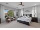 Relaxing main bedroom suite with a large window, dark wood accents, and a ceiling fan at 26648 W Quail Ave, Buckeye, AZ 85396