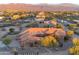 An aerial view of a custom desert home with a circular driveway surrounded by mature desert landscaping at 29423 N 145Th Pl, Scottsdale, AZ 85262