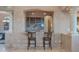 Bar area with stone countertops, wood cabinets, a sink, and two stools at 29423 N 145Th Pl, Scottsdale, AZ 85262