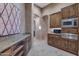 Butler's pantry area with custom cabinets, granite counters, microwave, and beverage cooler at 29423 N 145Th Pl, Scottsdale, AZ 85262