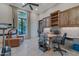 Spacious home office with built-in desk, shelving, and comfortable seating area at 29423 N 145Th Pl, Scottsdale, AZ 85262