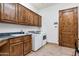 Laundry room with wood cabinets, sink, and modern washer and dryer units at 29423 N 145Th Pl, Scottsdale, AZ 85262