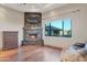 Living room with a stone fireplace, a flat-screen television, and a large window at 29423 N 145Th Pl, Scottsdale, AZ 85262