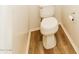 Picture shows a standard white toilet set against wood-look flooring at 40247 W Helen Ct, Maricopa, AZ 85138