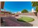 Serene backyard with a putting green, gravel area, hot tub, and covered patio for entertaining at 4102 E Cathedral Rock Dr, Phoenix, AZ 85044