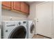 Well-lit laundry room featuring a modern washer and dryer set and ample overhead cabinet storage at 4102 E Cathedral Rock Dr, Phoenix, AZ 85044