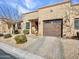 Beautiful exterior view showcasing the home's facade, lush landscaping, and an inviting brick driveway, perfect for curb appeal at 4241 N Pebble Creek Pkwy # 42, Goodyear, AZ 85395