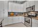 Close-up of a well-equipped kitchen with stainless steel appliances, white cabinetry, and modern countertop at 4241 N Pebble Creek Pkwy # 42, Goodyear, AZ 85395