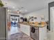 Open-concept kitchen featuring granite countertops, stainless steel appliances, an island with bar seating, and natural light at 4241 N Pebble Creek Pkwy # 42, Goodyear, AZ 85395