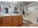 Bathroom featuring wood cabinets, double vanity, decorative art, and a glass shower at 5450 E Mclellan Rd # G227, Mesa, AZ 85205
