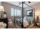 Well-lit bedroom featuring a four-poster bed, dark finishes, and a sunny window at 5450 E Mclellan Rd # G227, Mesa, AZ 85205