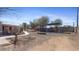 Large backyard with mature shade trees and an open patio area, ready for entertaining at 606 E Baseline Rd, Buckeye, AZ 85326