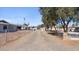 Long driveway leading to a gray home, surrounded by desert landscaping and chain-link fence at 606 E Baseline Rd, Buckeye, AZ 85326