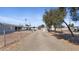 Long driveway leads to this gray home surrounded by desert landscaping and a chain-link fence at 606 E Baseline Rd, Buckeye, AZ 85326