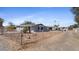 Desert landscaping surrounds a gray home with solar panels, featuring a long driveway at 606 E Baseline Rd, Buckeye, AZ 85326