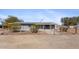 Cozy gray home featuring solar panels, desert landscaping, and a chain-link fence at 606 E Baseline Rd, Buckeye, AZ 85326