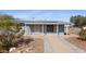 Charming home with a stucco facade, solar panels, and desert landscaping at 606 E Baseline Rd, Buckeye, AZ 85326
