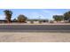 View of charming gray home with desert landscaping and solar panels on a quiet street at 606 E Baseline Rd, Buckeye, AZ 85326