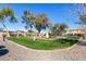 Community playground with modern play equipment, lush green grass, and surrounding trees at 7726 E Baseline Rd # 207, Mesa, AZ 85209