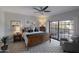 Cozy main bedroom with a wood-framed bed, neutral decor, ceiling fan, and sliding glass doors to the outside at 7955 E Chaparral Rd # 57, Scottsdale, AZ 85250