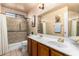 Bathroom with double sinks, vanity, neutral tile flooring, and an accessible walk-in shower at 9014 E Sharon Dr, Scottsdale, AZ 85260
