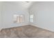 A bright, carpeted bedroom featuring a large window and neutral decor, offering a calm and inviting space at 911 E Lovegrass Dr, San Tan Valley, AZ 85143