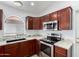 A well-lit kitchen showcases stainless steel appliances and beautiful granite countertops with dark wood cabinetry at 911 E Lovegrass Dr, San Tan Valley, AZ 85143