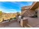 Outdoor kitchen featuring a stone surround BBQ, desert landscaping and scenic views at 9904 E Lookout Mountain Dr, Scottsdale, AZ 85262