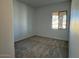 Empty bedroom featuring neutral carpet, natural light, and a scenic window view at 10027 W Verde Ln, Avondale, AZ 85392