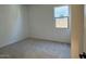 Neutral empty bedroom with carpet flooring and a single window with natural light at 10027 W Verde Ln, Avondale, AZ 85392