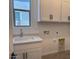 Well-lit laundry room with white cabinets, a sink, and washer-dryer hookups at 10027 W Verde Ln, Avondale, AZ 85392