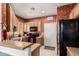 Kitchen with wooden cabinets, black appliances, and decorative floral wallpaper at 1015 S Val Vista Dr # 81, Mesa, AZ 85204